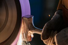 Abrasive belt grinding with sparks flying