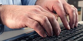 hands typing on a computer
