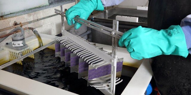 Person applying anodizing masking tape to protect flight-critical aluminum components from the chemical bath.