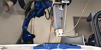 Image of a robot arm applying 3M™ VHB Extrudable Tape to a complex part at varying depths 
