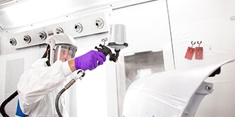 Technician priming a car for paint
