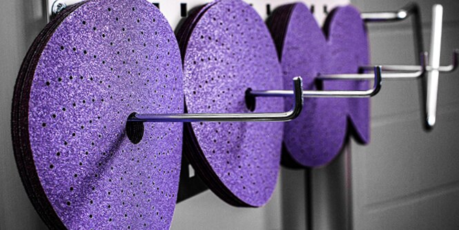 4 3M abrasive discs hanging on racks

