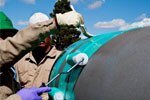 Man spraying Scotchkote&trade; Liquid Epoxy Coating 323+ protective coating on pipe