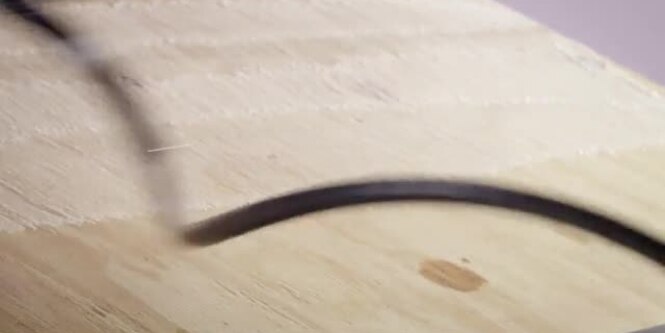 Video still of 3M™ HoldFast 70 Spray Adhesive being sprayed on plywood before rolling out roofing felt
