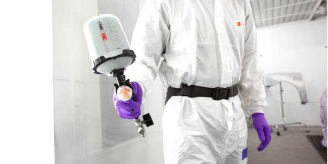 Worker holding 3M spray gun
