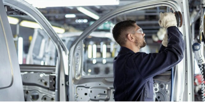 Worker sanding car door with 3M abrasives
