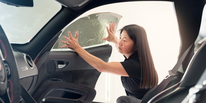 woman installing window tint on a car's passenger window

