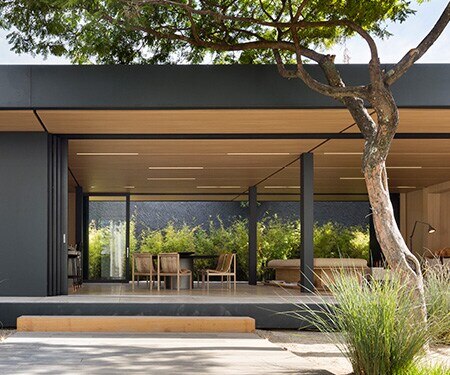 Exterior of modern home with matte black and light wood finishes
