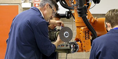 A group of system integrators programming a robot
