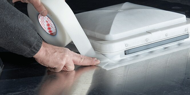 Image of handles applying water sealing tap around a vent
