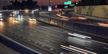 Roadway at night with reflective pavement markings.
