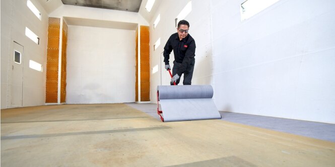 Worker applying floor protection film
