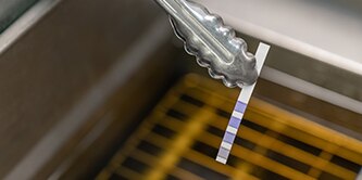 Oil monitoring strips being used to test oil
