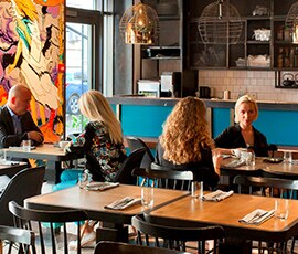 Four diners sitting in an inviting, clean restaurant.