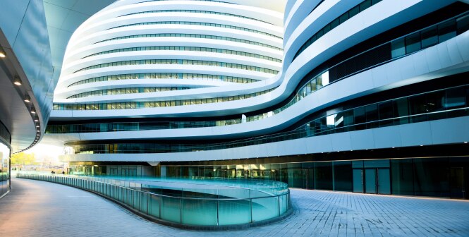 A modern architectural complex with sleek, curved lines and a futuristic design.
