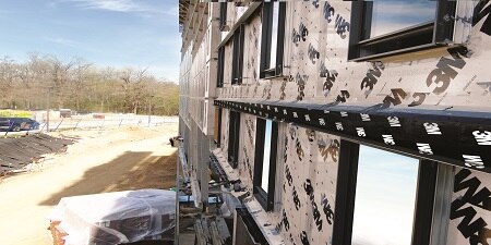Building siding under construction is covered with 3M protective membrane product.
