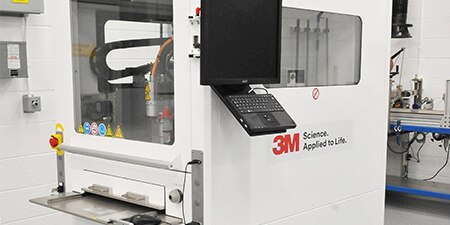Image of a gantry system with an entry slot and two windows for process visibility
