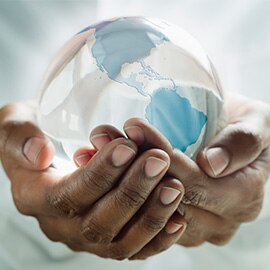 Person holding a clear globe in their hands.