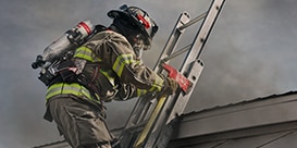 firefighter climbing ladder outside building
