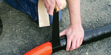 Worker wrapping large cable with 3M Mining Tape
