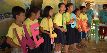 Children holding a welcome sign.
