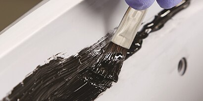 brushing seam sealer onto primed metal
