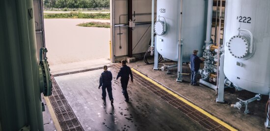 Two 3M Cordova plant employees exiting the plant floor through a large entrance.
