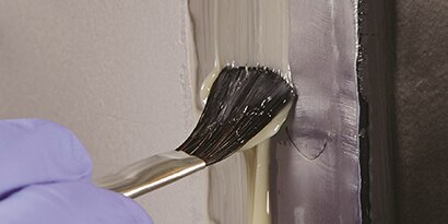 brushing seam sealer onto unprimed metal
