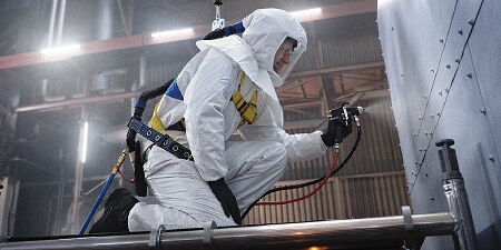 Worker Painting with PPE
