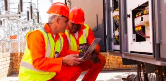 Two workers working on an electrical substation.
