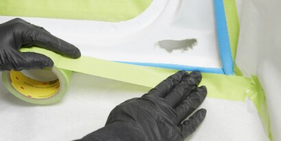 technician masking a car with 3M green tape
