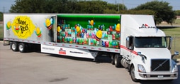 long fleet truck with a colorful graphic wrap.