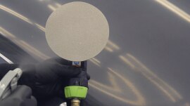 Water being sprayed on the disc and area before sanding