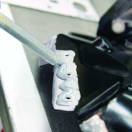 Silver structural adhesive being applied to automotive part