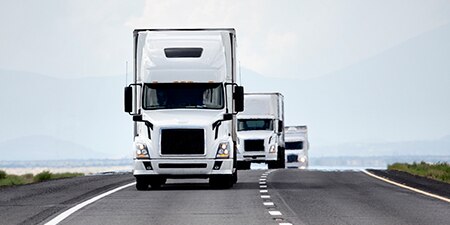 Fleet semi trucks on a highway.
