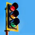 Highly visible stoplight against blue sky.