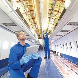 Two people working on interior of aircraft
