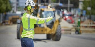 Worker in PPE directing traffic
