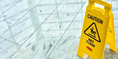 clean floor with a 'caution - wet floor' yellow pop-up sign.
