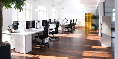 Sunny office with large windows on the left side.
