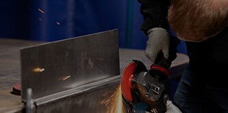 Worker finishing mild steel with Scotch-Brite Heavy Duty Surface Conditioning Disc
