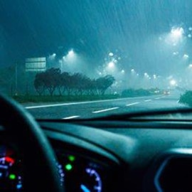 A driver’s point of view of the road in the dark and the rain, as the pavement markings are illuminated and easy to see.
