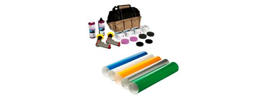 Five rolls of automotive film, a tool bag, two squirt bottles, two power tools, and a variety of finishing pads.
