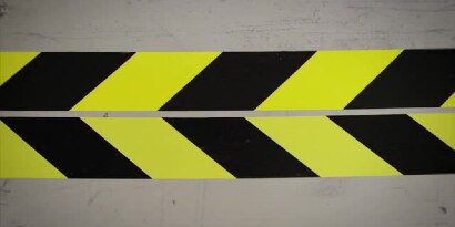 Video still of two yellow-and-black tapes next to each other, lined up so the connecting edges form arrows pointing left
