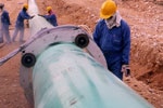 Worker inspecting epoxy coated pipe