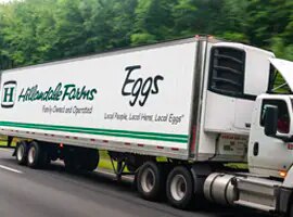 truck driving down the highway with a fleet graphic for hillandale farms